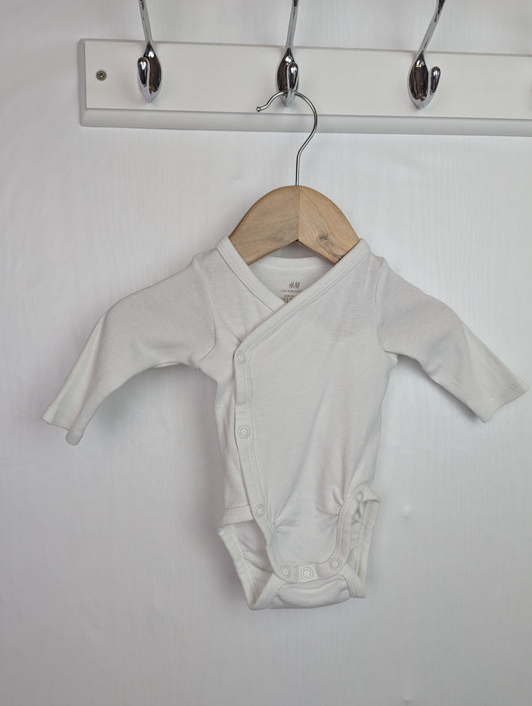 H&M White Wrap Bodysuit - Unisex 0-1 Month Little Ones Preloved Used, Preloved, Preworn Baby, Girls & Boys Clothes. Kids & Children's second hand Clothing UK Online. Cheap affordable. Brands including Next, Joules, Nutmeg Morrisons, TU, F&F, H&M.