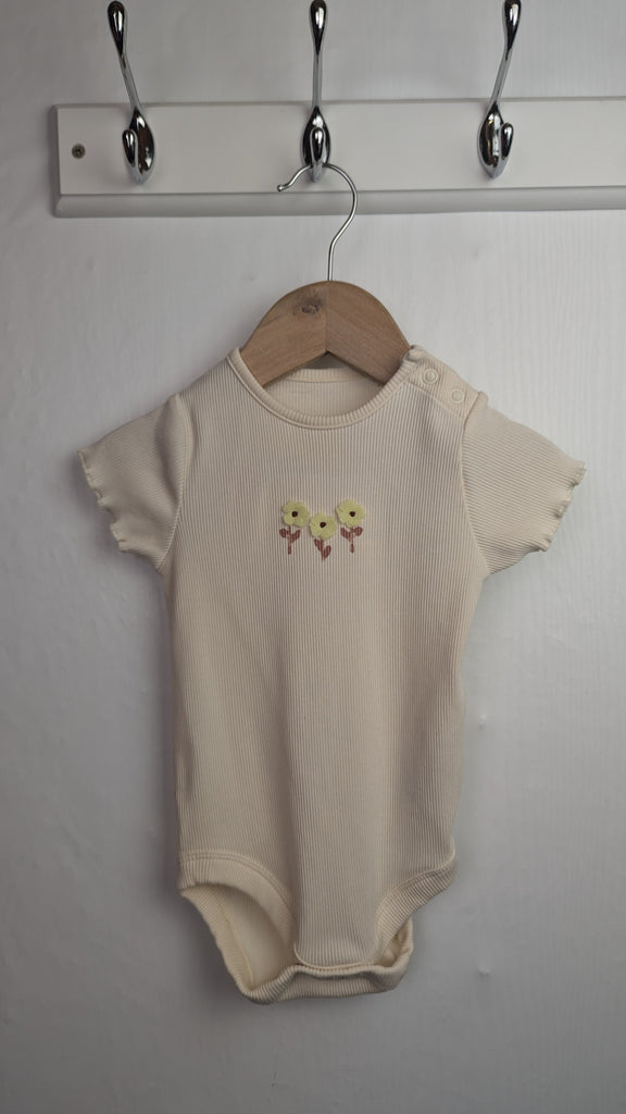 M&S Cream Ribbed Floral Bodysuit - Girls 9-12 Months Little Ones Preloved Used, Preloved, Preworn & Second Hand Baby, Kids & Children's Clothing UK Online. Cheap affordable. Brands including Next, Joules, Nutmeg Morrisons, TU, F&F, H&M.